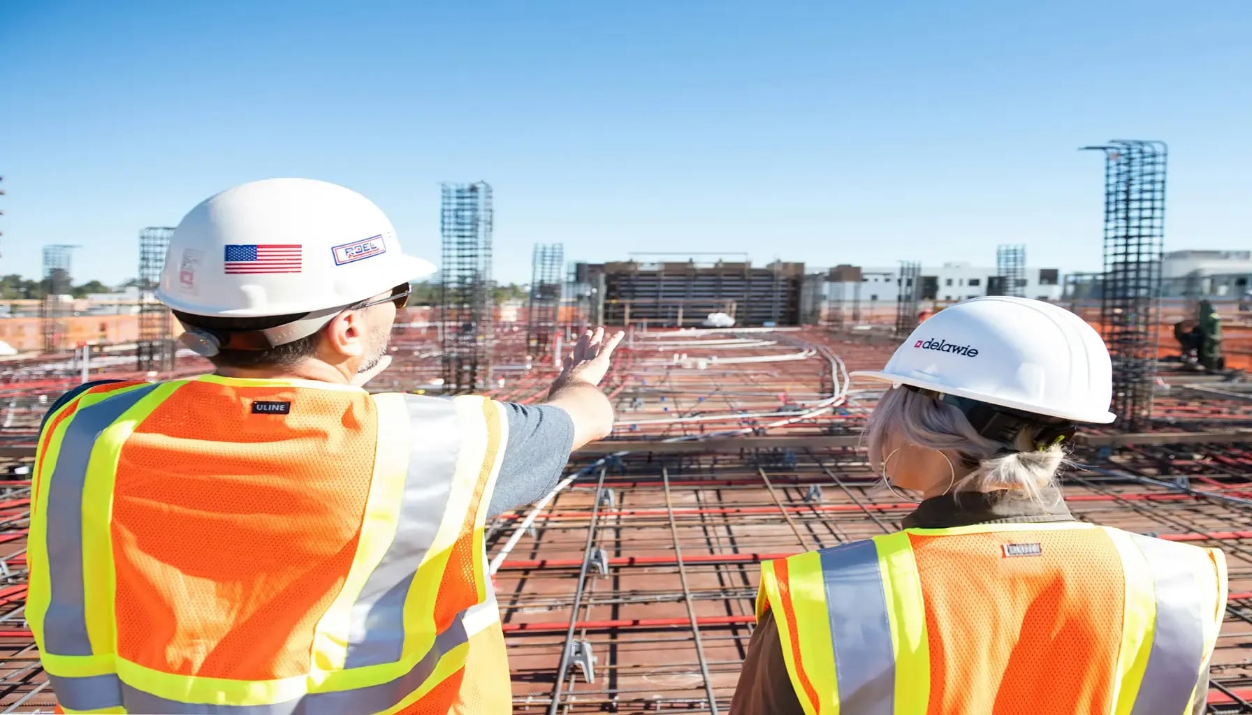 Individuals in construction vests overlooking a jobsite